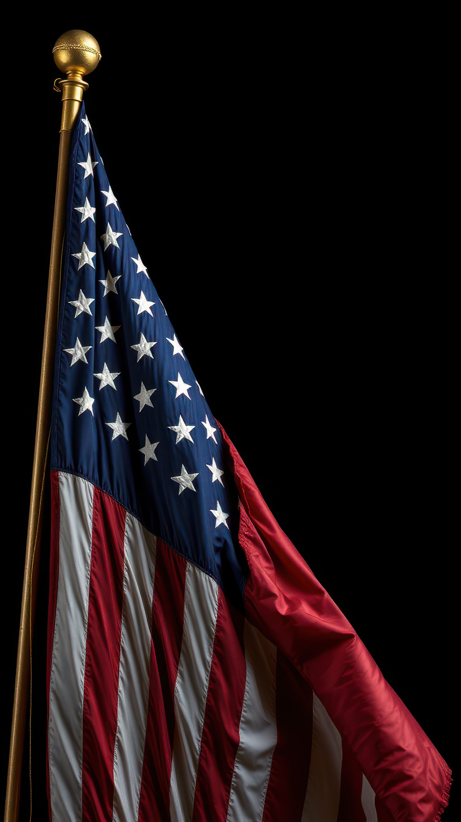 American flag waving proudly against a dark background highlighting its colors and design details in a somber, elegant display